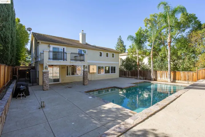 Back of property featuring a fenced backyard, stucco siding, and a patio