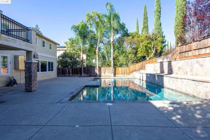 View of swimming pool featuring a fenced backyard and a patio