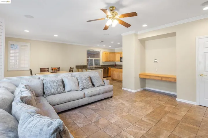 Living area with recessed lighting, crown molding, and ceiling fan