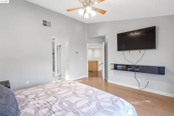 Bedroom featuring light wood-style floors, ceiling fan, and lofted ceiling