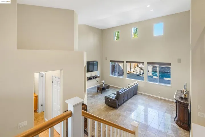 Living room featuring a towering ceiling and baseboards