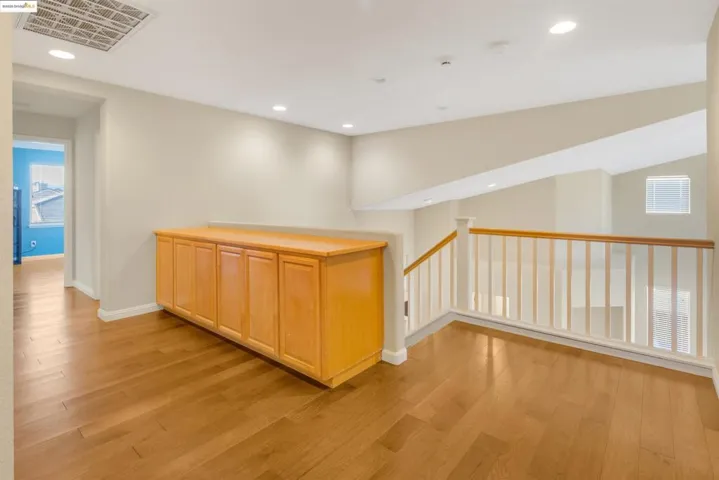 Hallway with recessed lighting, lofted ceiling, and light wood-style flooring