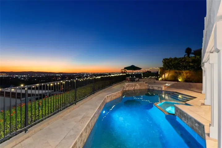 The resort-style backyard offers a saltwater pool and spa with a waterfall feature