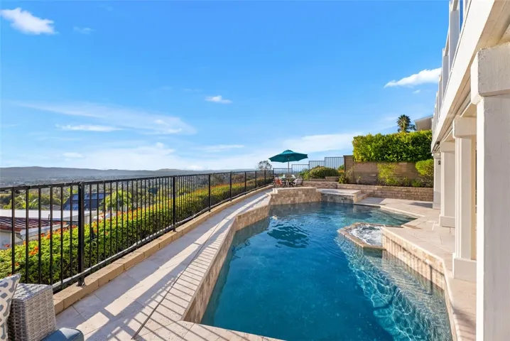 The resort-style backyard offers a saltwater pool and spa with a waterfall feature