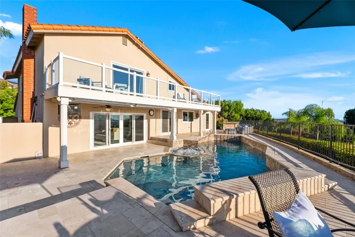 The resort-style backyard offers a saltwater pool and spa with a waterfall feature