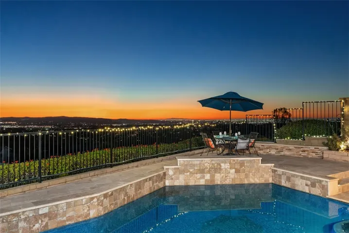 The resort-style backyard offers a saltwater pool and spa with a waterfall feature