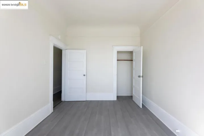 Unfurnished bedroom with wood finished floors and a closet