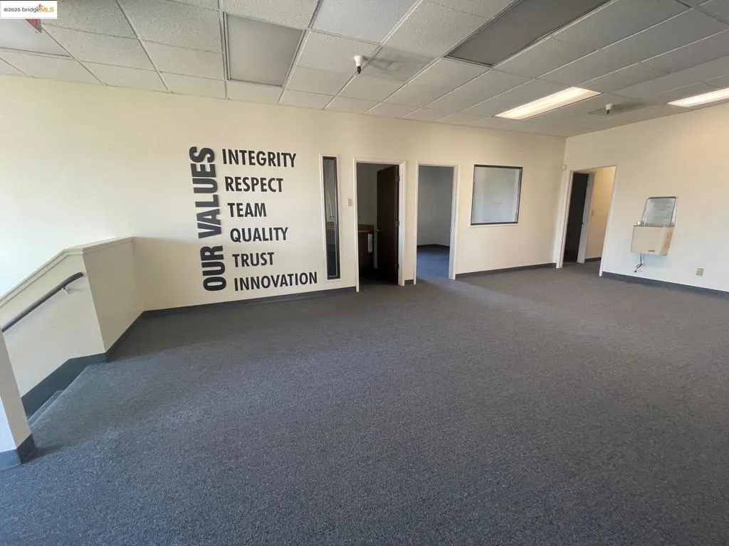 Unfurnished room with a paneled ceiling and dark carpet