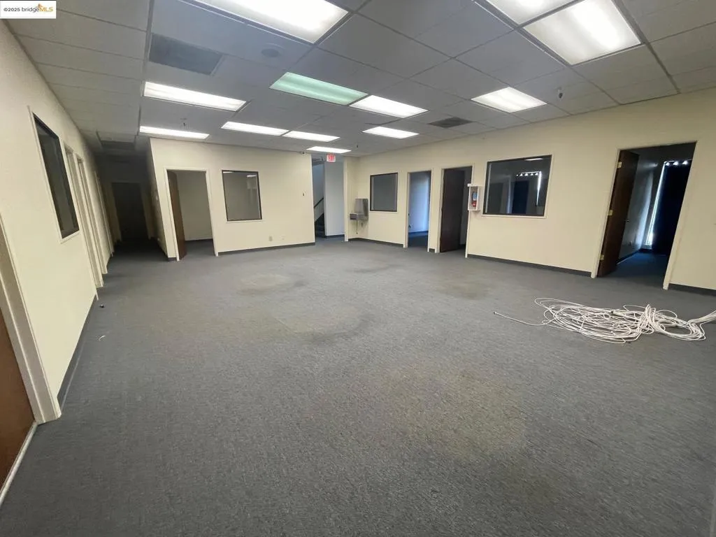 Carpeted spare room with baseboards and a paneled ceiling