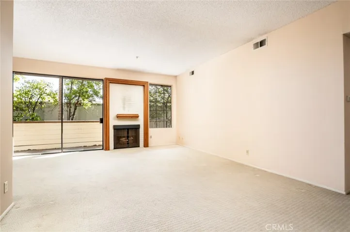 The living room offers large windows, glass sliding door, and fireplace!