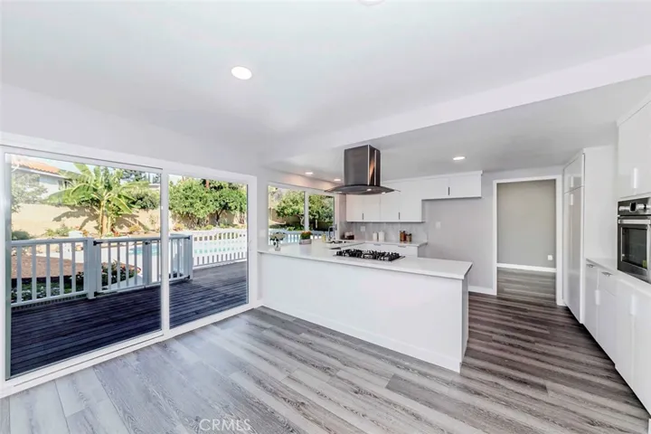 Patio doors off kitchen opens out to fenced wood deck overlooking the pool.