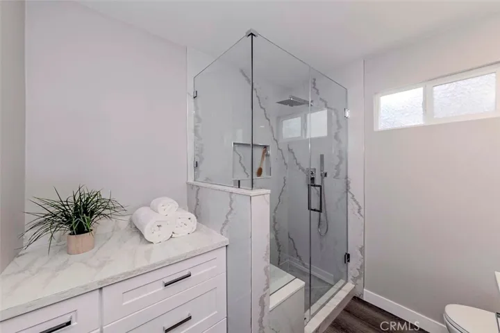 Remodeled large downstairs bathroom with bench and "rain forest" showerhead and storage cabinet.