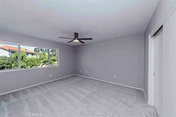 Primary bedroom suite features new ceiling fan and 3 closets (1 in bedroom and 2 in the remodeled bathroom).