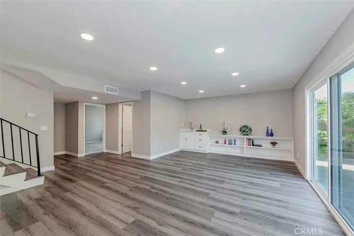 Downstairs great room features a wet bar and plenty of shelving.