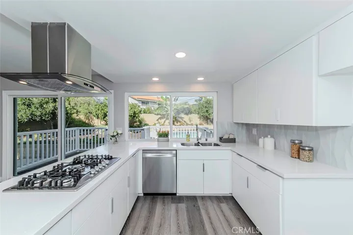 Remodeled kitchen feature new cabinetry, dual sinks, and stainless steel appliances.