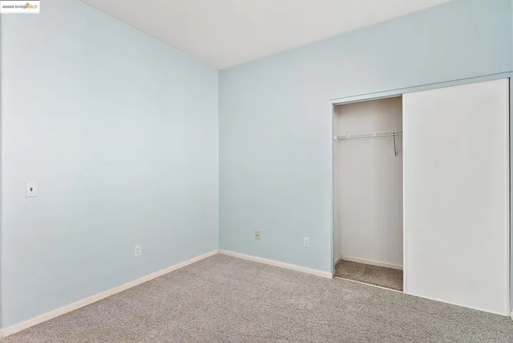 Unfurnished bedroom featuring carpet flooring and a closet