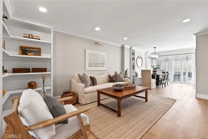 Living room with builtin bookcase, crown moulding, base and case upgrades and updated recessed lighting throughout.  LVP flooring.