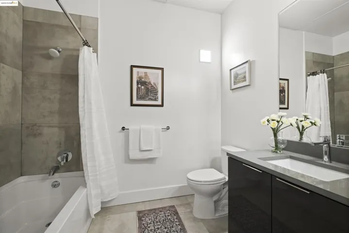 Bathroom with vanity, light tile patterned floors, and shower / bath combination with curtain