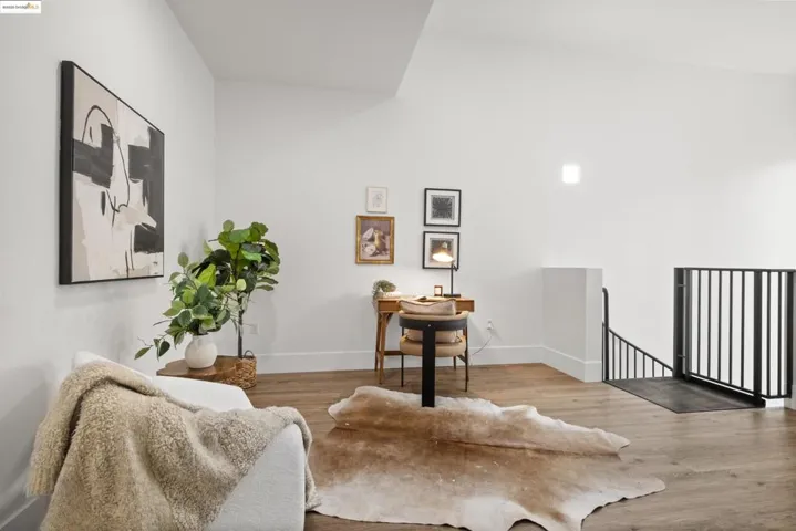 Sitting room featuring an upstairs landing, wood finished floors, and a desk