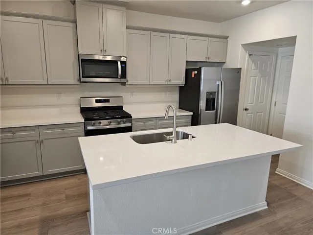 Large kitchen with island, quartz countertops and stainless appliances