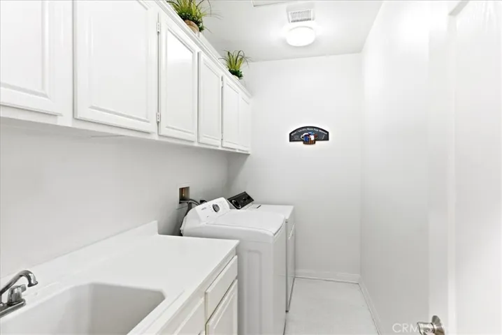 Laundry Room with lots of cabinets for storage and washing sink.