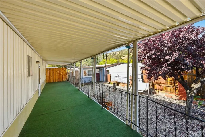Covered front porch overlooks the side yard with office space entry in the center of the photo.