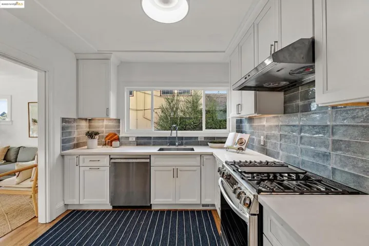 Kitchen featuring appliances with stainless steel finishes, white cabinetry, and under cabinet range hood