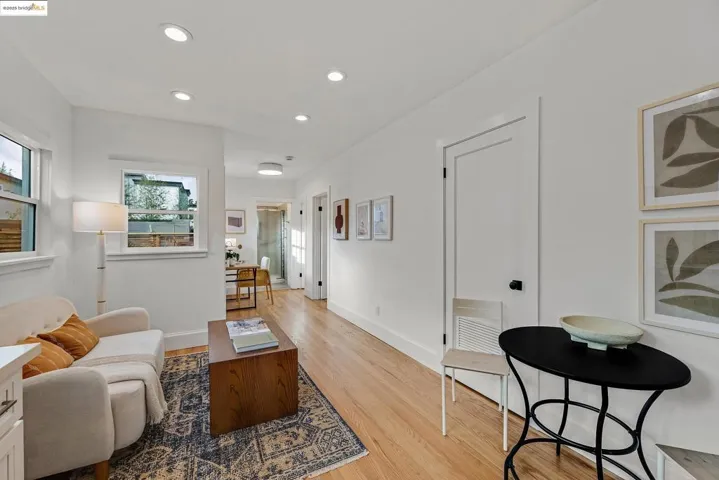 Living area with light wood-type flooring and recessed lighting