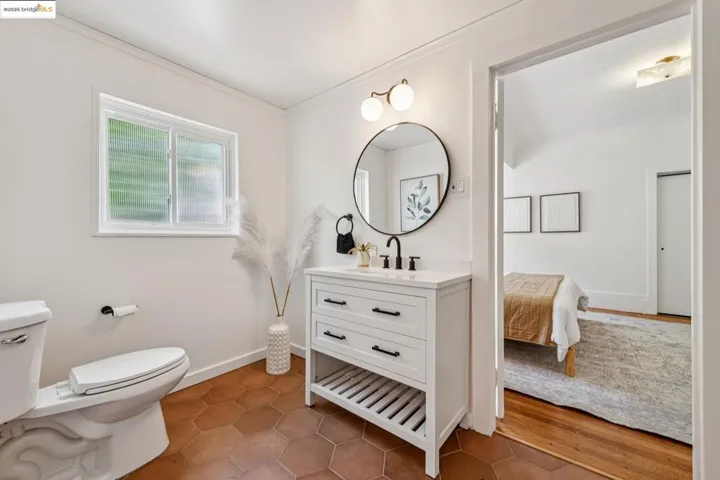 Bathroom featuring vanity, dark tile patterned flooring, and ornamental molding
