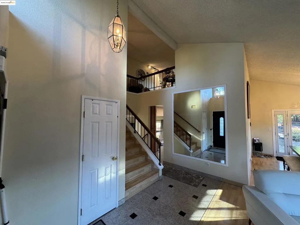 Staircase featuring high vaulted ceiling and baseboards