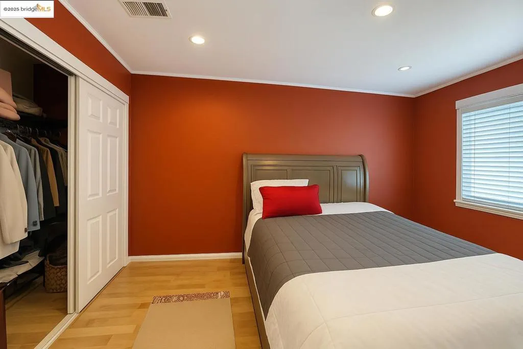 Bedroom featuring light wood-style flooring, crown molding, recessed lighting, and a closet