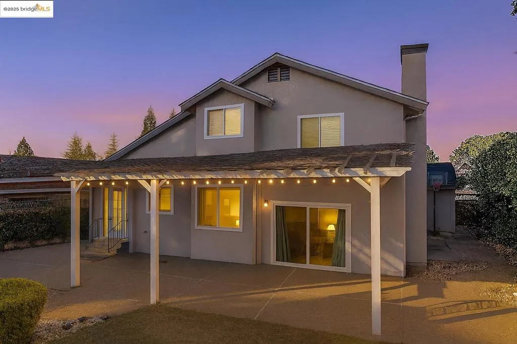 Rear view of property with a patio, stucco siding, and a chimney