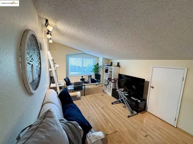 Living room featuring a textured ceiling and wood finished floors