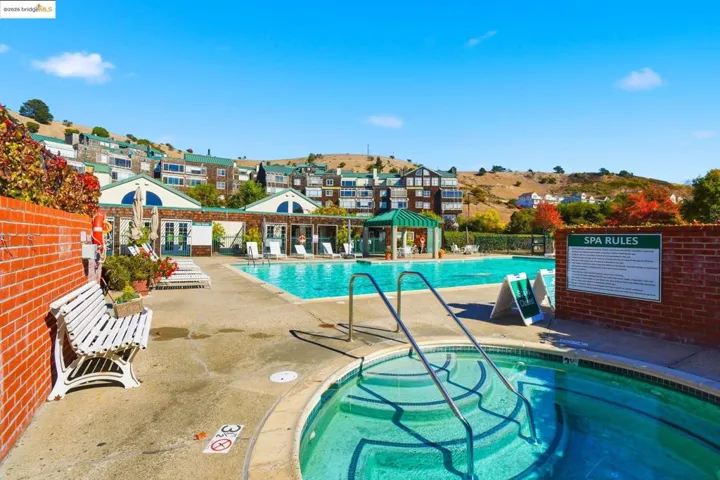 Community pool featuring a community hot tub and a patio area