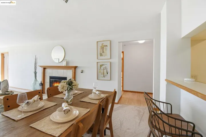 Dining room featuring a tile fireplace and light wood-style floors