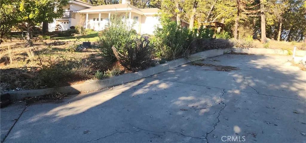 Driveway to lot with neighbors home in background
