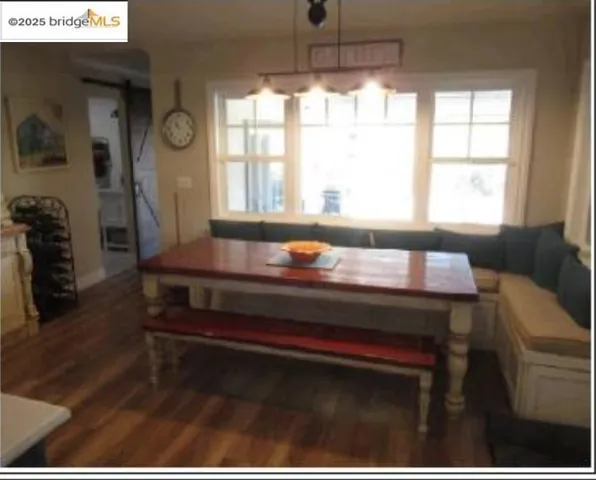 Dining area featuring a barn door, breakfast area, healthy amount of natural light, and dark wood-style flooring