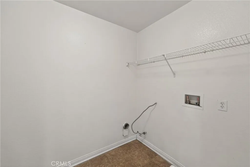 Spacious laundry room with hookups and shelving