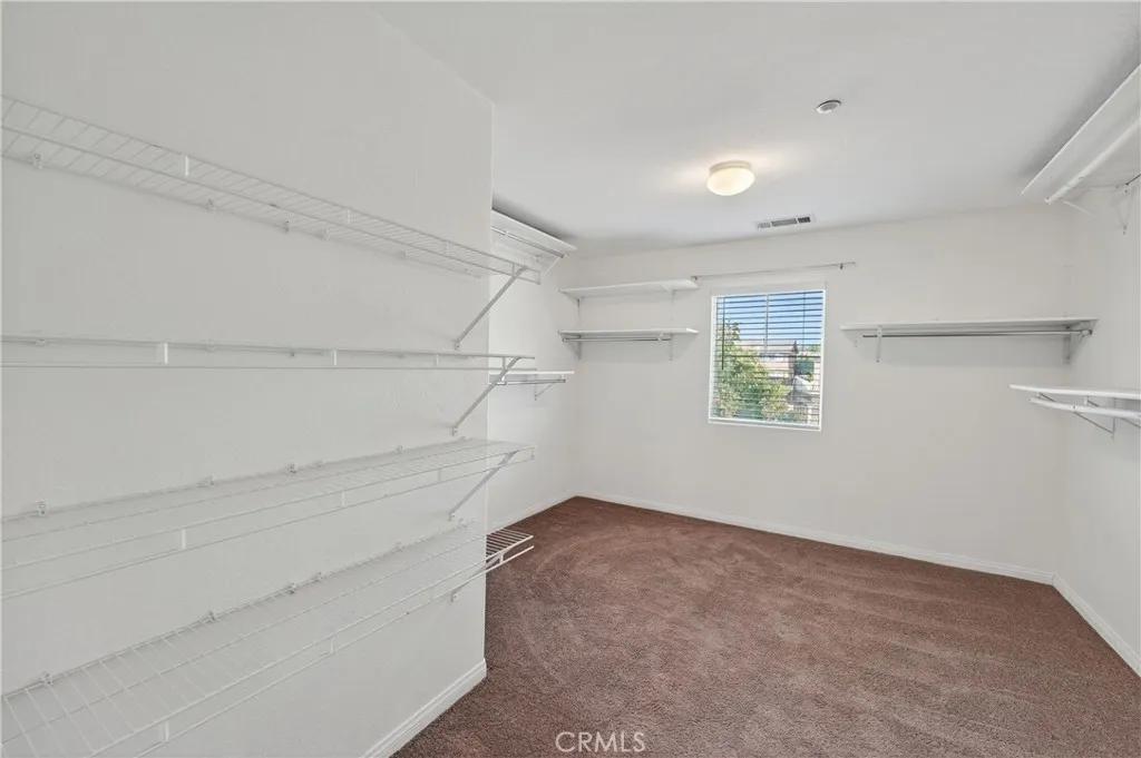 Oversized walk-in closet offering plenty of storage and shelving