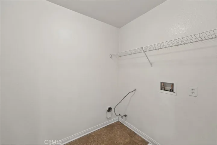 Spacious laundry room with hookups and shelving