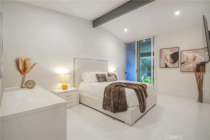 Harmonious secondary bedroom offers sliding door to palm lined Koi pond