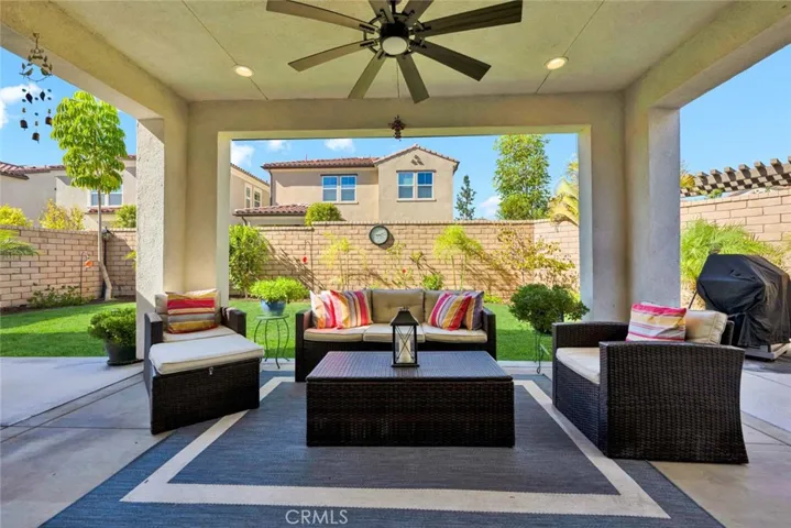 Outdoor back patio with patio cover and fan.