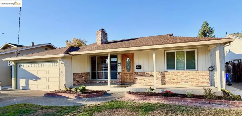 Ranch-style house with covered porch, a garage, a chimney, brick siding, and driveway