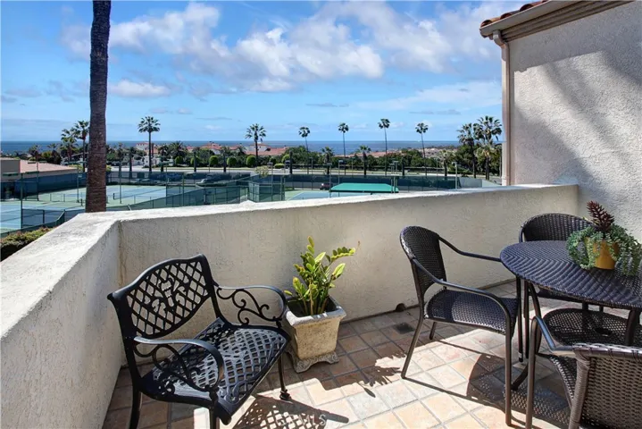 Another view of tennis courts and beautiful vistas of ocean and palm trees.