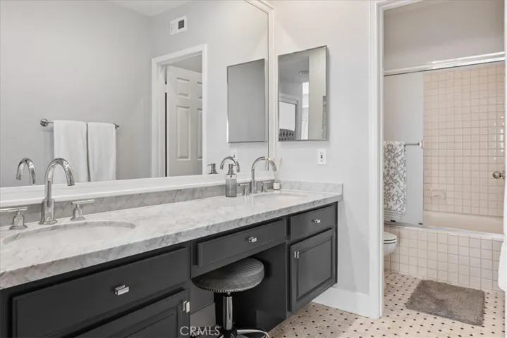 Remodeled guest bathroom with marble counters, bathtub and shower.