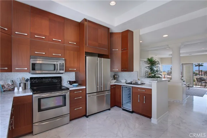 Remodeled kitchen with marble counters, built in range and microwave.