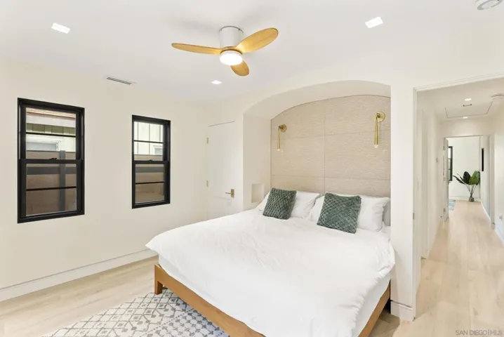 The guest bedroom feels like a private retreat, soft coastal light over linen textures, a quiet reading nook, and serene garden views that ease every arrival.