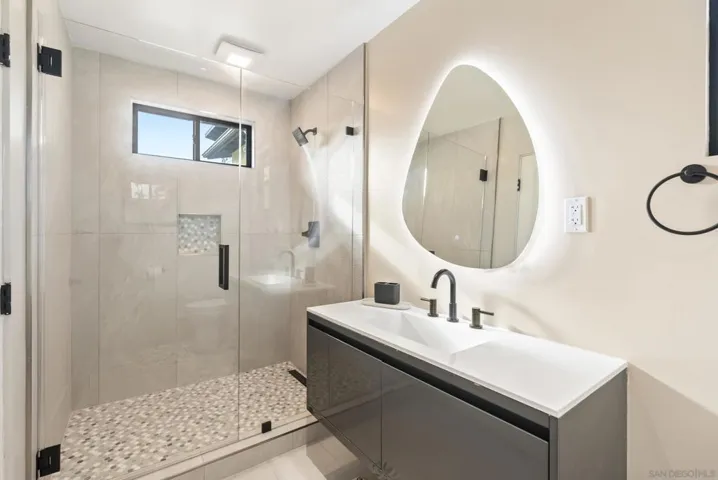 Guest house bathroom with layered lighting that feels like a private spa.