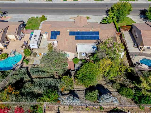 The backyard features mature landscaping on the sloped terrain, offering natural shade and a picturesque setting.