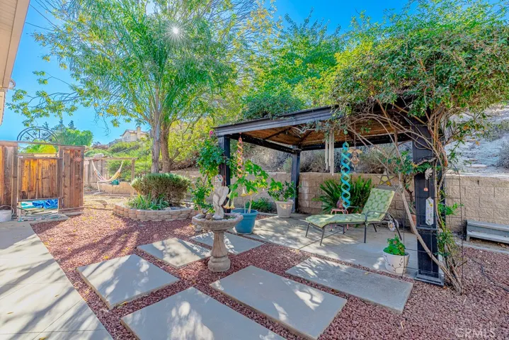 The charming gazebo offers versatility—perfect for setting up an outdoor BBQ or enjoying a peaceful moment by the water fountain.